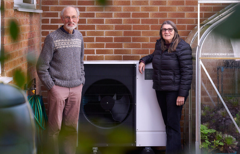 Aged Couple Standing besdie the residential modern air source heat pumps